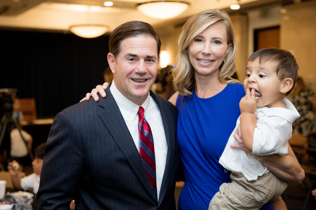 Governor Ducey with Darcy Olsen holding a foster child