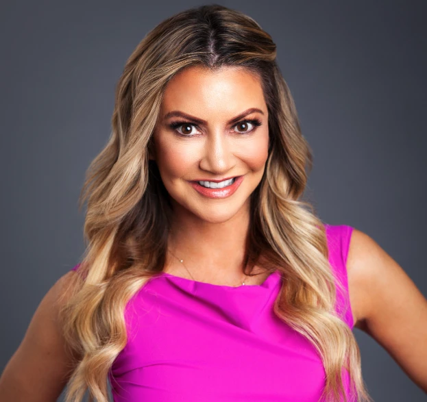 Carey Pe&ntilde;a, Emmy Award-winning journalist and community advocate, smiling in a vibrant pink dress, promoting advocacy for children and fostering connections at the Center for the Rights of Abused Children event.