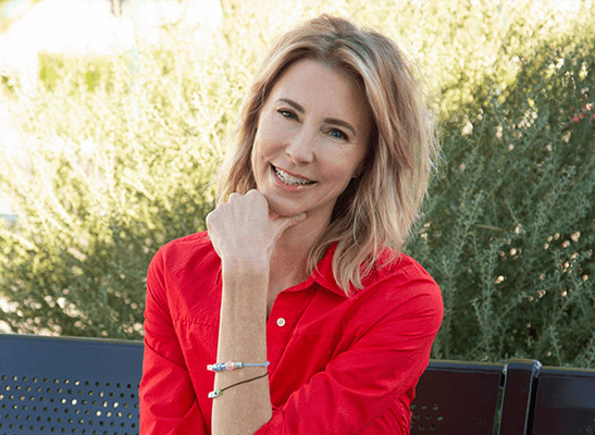 Darcy Olsen, founder and CEO of the Center for the Rights of Abused Children, smiling in a red shirt, promoting child welfare advocacy.