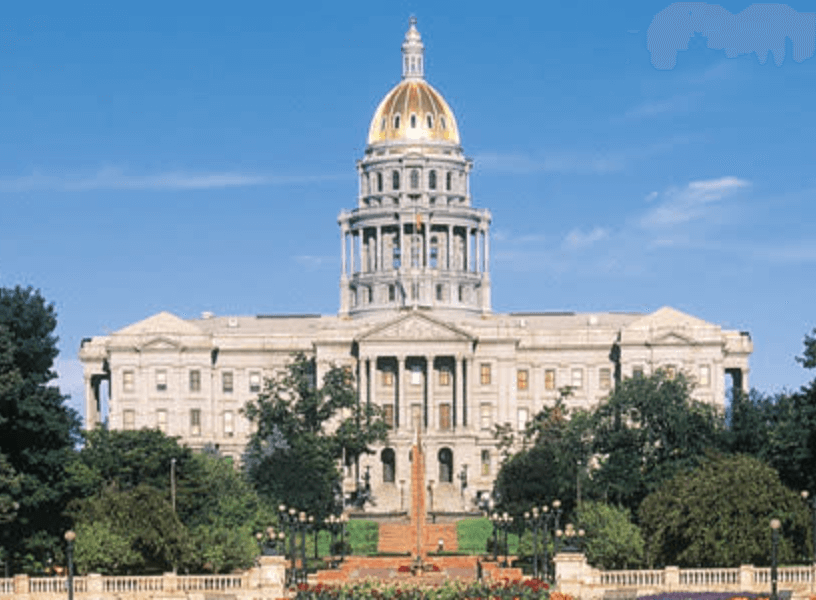 Colorado State Capitol building, symbolizing recent legal reforms for children's rights in foster care, surrounded by greenery and clear blue sky.