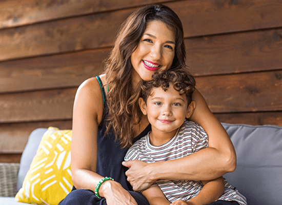 Smiling mother embracing young son, highlighting family bonds and well-being, relevant to Arizona's relative search bill for foster care.